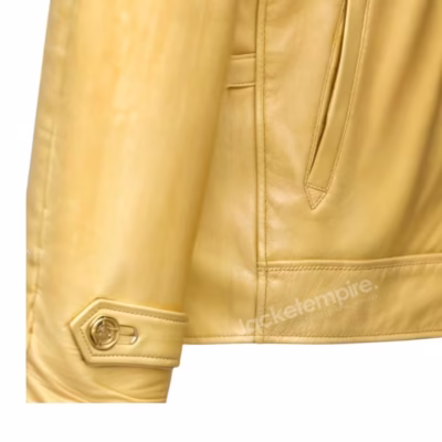 Close-up detail of yellow leather jacket showing quality stitching and designer cuff button